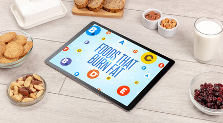 Healthy Tablet Pc compostion with FOODS THAT BURN FAT inscription, weight loss concept