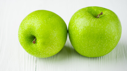 Apples. Two organic Green Granny Smith Apple. Healthy vegetarian diet. Fruits on natural white wooden background. 