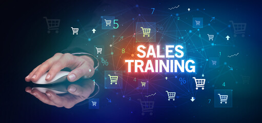 hand holding wireless peripheral with SALES TRAINING inscription, online shopping concept