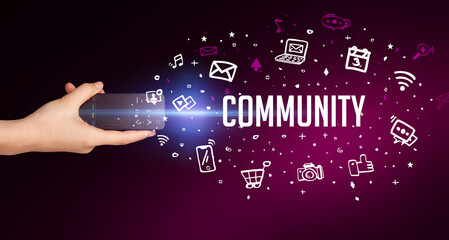 hand holding wireless peripheral with COMMUNITY inscription, social media concept