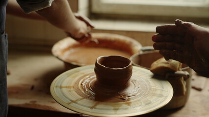 Man and woman sculpting in pottery. Girl preparing to modeling in workshop