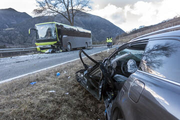 Violent head-on collision between a bus and a car traveling in the opposite direction at the end of the day. A victim due to high speed or drunk driving car crash at sunset or sunrise. 