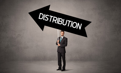 Young business person in casual holding road sign with DISTRIBUTION inscription, business direction concept