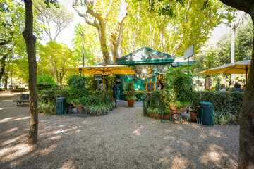 Fototapeta na wymiar A small snack shop with a lush garden patio inside the Borghese Gardens in Rome, Italy