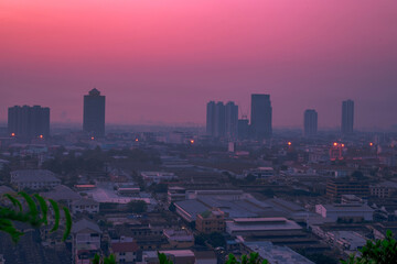 Obraz premium The blurred abstract background of the morning sun exposure to the tiny dust particles that surround the tall buildings in the capital, the long-term health issue of pollution.