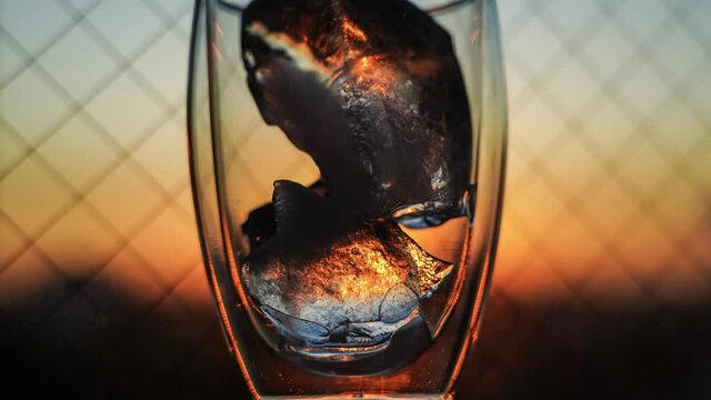 4K time lapse of color collaboration with  ice in the glass and sky at blue moment. Color changes with time passing toward sunrise. This is taken in room due to COVID-19 situation.