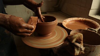 Artist sculpting from wet clay in studio. Master making clay pot in workshop