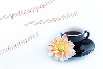 ダリアの花と黒いコーヒーカップに入れたコーヒーと楽譜の合成
