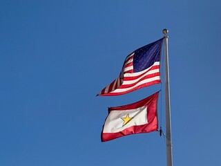American Flag and Gold Star Service Flag Waving in the Wind with Blue Sky Background