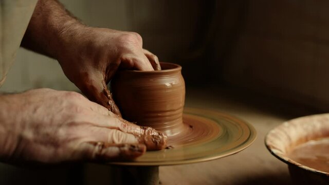 Artist sculpting clay product in pottery. Man producing new product in workshop