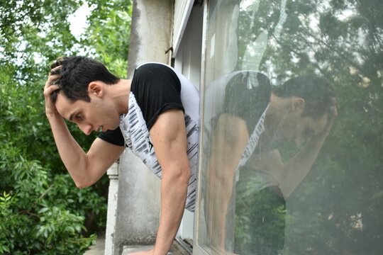 Worried guy reflected on window