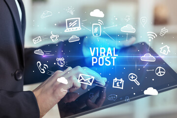 Fototapeta premium Close-up Of A Person Using Social Networking with VIRAL POST inscription