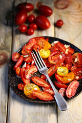 Selective focus. Rustic tomato salad with olive oil on a plate. Tomato salad. Delicious homemade salad.