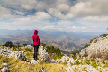 Obraz premium Beautiful scenery in the mountains with sharp limestome rocks, hiking path and April sky and showers, with cumulus clouds
