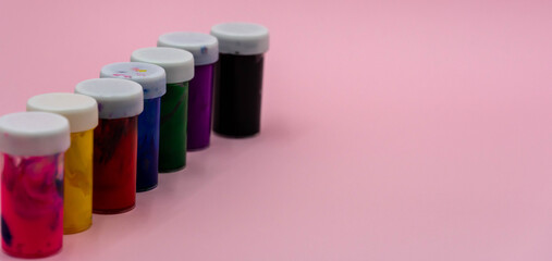 Set of watercolor paints on pink background closeup. Selective focus.
