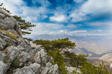 Fototapeta na wymiar Beautiful scenery in the mountains with sharp limestome rocks, hiking path and April sky and showers, with cumulus clouds