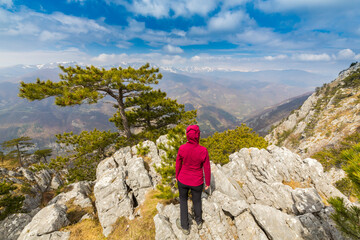 Beautiful scenery in the mountains with sharp limestome rocks, hiking path and April sky and showers, with cumulus clouds