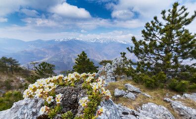 Beautiful scenery in the mountains with sharp limestome rocks, hiking path and April sky and showers, with cumulus clouds