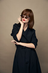 Fototapeta premium Stylish Woman Looks up and holds his hand near his face bright makeup elegant appearance 