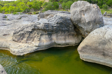 Fototapeta na wymiar The Pedernales river forms geological rock pools with beautiful limestone formations. Spring at the Pedernales River Falls State Park in Texas., Burnet Texas Central Texas Hill Country