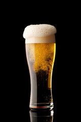 glass of beer with bubbles and thick white foam, isolated on black background