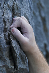 A single male hand on a cliff, rock climbing
