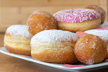 Was Süßes zum Fasching. Berliner Ballen und Donuts auf einem Teller, alles zum Karneval, Nahaufnahme. 