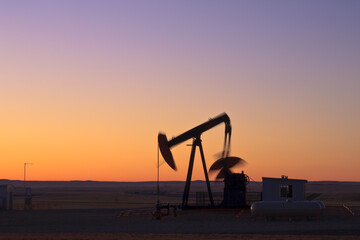 Fototapeta premium Oil pump jack at sunrise in Alberta, Canada