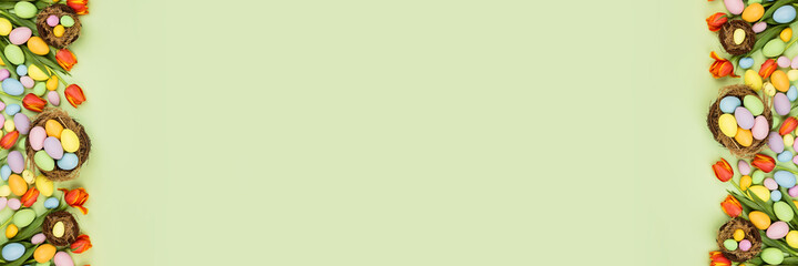 Stylish background with colorful easter eggs pastel colors isolated on green background. Horizontal...