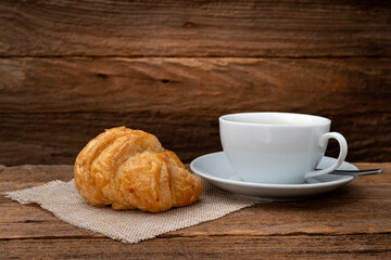 coffee aand croissants on old wooden.