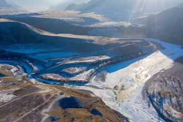Aerial view of confluence of Chuya river with Katun river on sunny winter day. Altai Republic,...