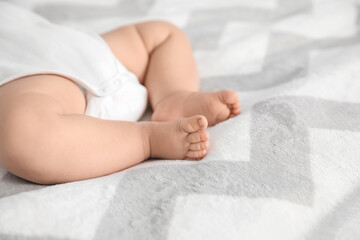 Legs of cute little baby sleeping on bed