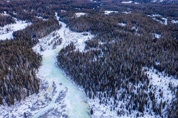 Winter Altai aerial landscape. Covered with blue ice river goes through taiga. - obrazy, fototapety, plakaty
