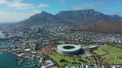 Wide aerial shot tracking forward into the city of Cape Town during a spectacular sunrise with Table Mountain in the background.
