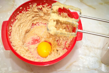 Red bowl with egg yolk and dough