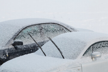 Car in a snowdrift with wipers sticking out so as not to freeze