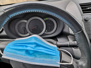 Protective face mask on car steering wheel in connection with the obligation of the mask in the...