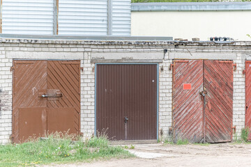 Fototapeta premium private garage doors. Dilapidated wooden doors in a brick wall.