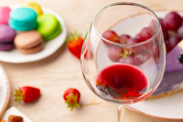 Glass of red wine with appetizer on table close up