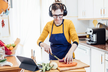 woman cooking using tablet to follow the recipe