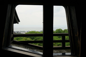 City landscape and green forest from Trapezoid shaped window of Hikone Castle in Shiga prefecture, Japan - 日本 滋賀県 彦根城の窓からの眺望 