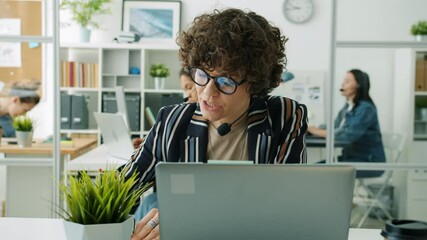 Portrait of attractive lady call center worker talking phoning and typing with laptop in workplace. Modern technology and customer support service concept.