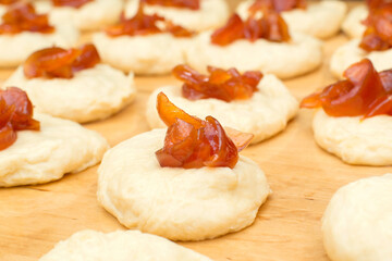 blanks with dough with jam for making buns, pies, donuts Cooking process with yeast dough with filling, close-up, background