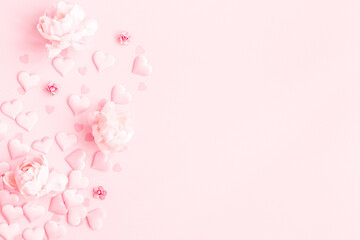 Fototapeta na wymiar Valentine's Day background. Frame made of pink flowers, hearts on pastel pink background. Valentines day concept. Flat lay, top view, copy space