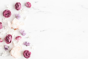 Flowers composition. White and purple flowers on marble background. Flat lay, top view - 413143954