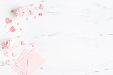 Valentine's Day background. Pink flowers, envelope, hearts on marble background. Valentines day...