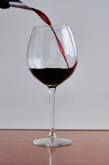 red wine is poured into a glass