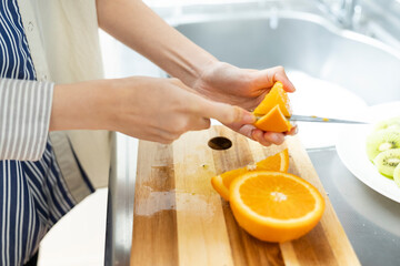 オレンジを着る手元