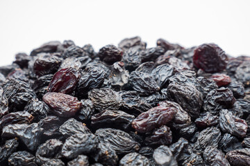Black raisins on the white background. Vegetarian healthy snack. Organic food. Vegetable diet