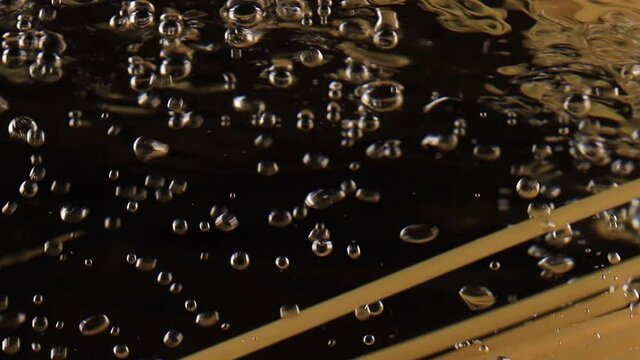 Traditional Italian cuisine slow motion Throwing spaghetti pasta into water on black background. High quality FullHD footage